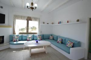 a living room with a blue couch and a table at Bianca Suite & Home in Psinthos