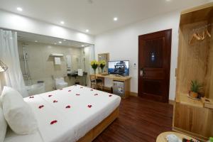 a bedroom with a bed and a bathroom with a television at Blue Hanoi Inn City Hotel in Hanoi