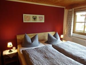 a bedroom with red walls and a bed with pillows at Landhaus Schmid in Oberstdorf