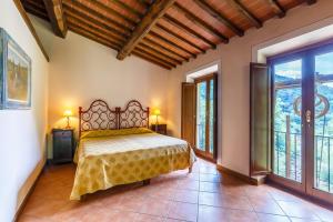 sypialnia z łóżkiem i dużymi oknami w obiekcie Villaggio Albergo San Lorenzo e Santa Caterina w mieście Pescia