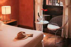 a hat on a bed and a chair in a room at Hotel San Roque in Garachico