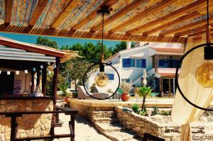 a patio with a wooden pergola and a table with a surfboard at João Jungle in Açafora