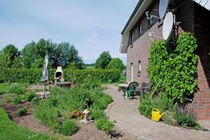 a garden with a table and chairs next to a brick building at Ferienwohnungen zum Neuensiener See P in Lancken-Granitz