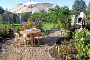 una mesa y sillas con una sombrilla en el jardín en Ferienwohnungen zum Neuensiener See P, en Lancken-Granitz