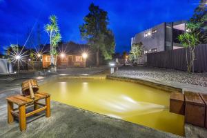un estanque amarillo frente a un edificio por la noche en Ruisui Sunshine Hot Spring B&B, en Ruisui