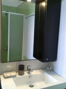 a bathroom with a sink with a large mirror at Stegadi Apartments Sikinos in Síkinos