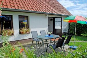 eine Terrasse mit einem Tisch, Stühlen und einem Sonnenschirm in der Unterkunft Ferienhaus in Lauterbach mit Kachelofen in Lauterbach
