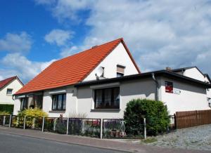 Klein ZickerにあるFerienhaus Christaのオレンジ色の屋根の白い家