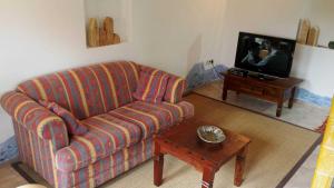 ein Wohnzimmer mit einem Sofa und einem Tisch mit einem TV in der Unterkunft Ferienhaus in Lauterbach mit Kachelofen in Lauterbach