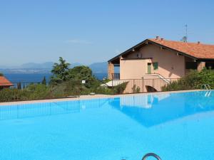 een groot blauw zwembad voor een huis bij Spacious Holiday Home with Private Garden and Barbecue in Lazise