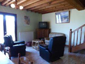 ein Wohnzimmer mit 2 Stühlen und einem TV in der Unterkunft Gite Equipe avec Espace Vert in Barrais-Bussolles