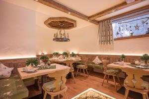 ein Restaurant mit Holztischen und -stühlen und einem Fenster in der Unterkunft Gästehaus Hölzl in Itter