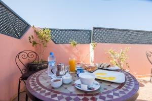 a table with food and drinks on a patio at Ryad Hamza in Marrakesh