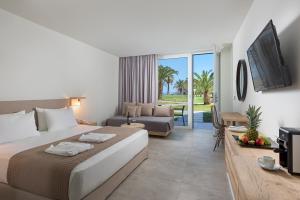 Habitación de hotel con cama y sala de estar. en Sun Beach Resort en Ialyssos
