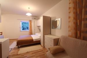 a small bedroom with a bed and a couch at Villa Violić in Zaton
