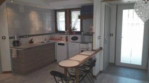 a kitchen with a table and some chairs in it at Le Gite Du Bucheron in Dabo