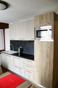 uma cozinha com armários brancos e um micro-ondas em La Maison de Pagan Alloggio ad uso turistico VDA CHARVENSOD n 0021 em Aosta