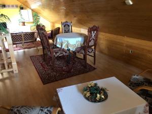 a table with chairs and a bowl of flowers on a table at Adele Rooms Nova Lesna in Nová Lesná