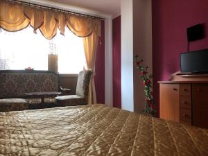 a bedroom with a bed and a chair and a window at Adele Rooms Nova Lesna in Nová Lesná