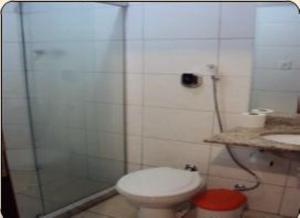 uma casa de banho com um WC e uma cabina de duche em vidro. em Estalagem Motel (Adult Only) no Rio de Janeiro