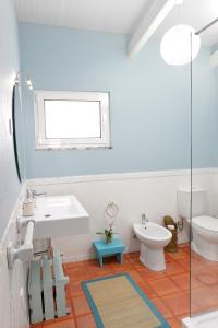 ein weißes Badezimmer mit Waschbecken und Toilette in der Unterkunft Casa na Areia in Lavos + 35 Fotos