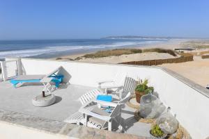 a view of a patio with chairs and the beach at Casa na Areia in Lavos