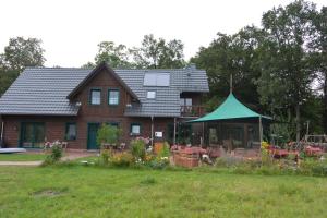 una casa con una tienda verde delante de ella en Ferienhof "Zum Spreewäldchen", en Burg