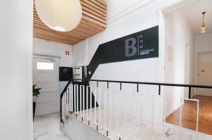 een trap in een gebouw met een bord aan de muur bij Nazaré Hostel - Rooms & Dorms in Nazaré