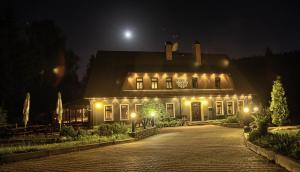 ein beleuchtetes Haus in der Nacht mit dem Mond in der Unterkunft Hotel Perla Jizery in Josefův Důl u Jablonce nad Nisou