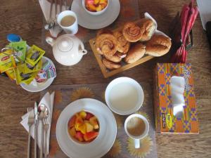 a table topped with cups of coffee and a plate of pastries at Cheers Guesthouse in Botianaw
