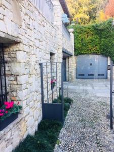 a stone building with a gate next to a garage at Villa Maddalena in Ome