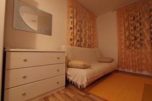 a bedroom with a dresser and a chair with a mirror at Villa Violić in Zaton