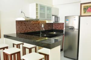 a kitchen with a black counter top and a refrigerator at Apartamento Praia Meireles in Fortaleza