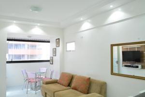 sala de estar con sofá y mesa con sillas en Apartamento Praia Meireles, en Fortaleza