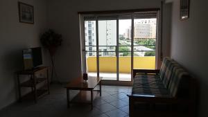 een woonkamer met een bank en een groot raam bij Gaivota Sun in Portimão