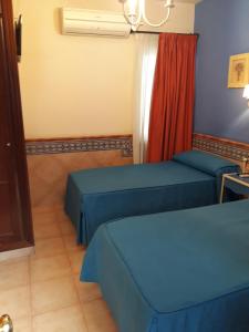 a room with two beds and a window at Pension Doña Trinidad in Seville