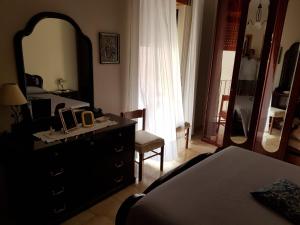 een slaapkamer met een dressoir, een spiegel en een bed bij B&B Via Roma in Viggianello