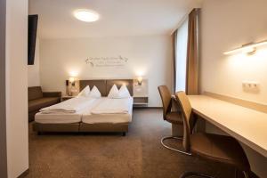 a hotel room with a bed and a desk at Hotel Lokomotive in Linz