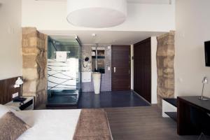 ein Schlafzimmer mit einem Bett und ein Badezimmer in der Unterkunft Hotel Restaurante Masía la Torre in Mora de Rubielos