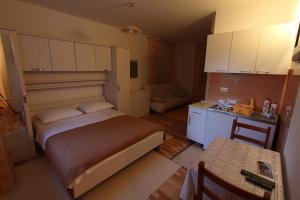 a small bedroom with a bed and a kitchen at Villa Violić in Zaton