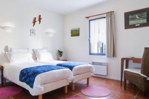 1 dormitorio con cama, ventana y silla en Hôtel Le Chevalier Gambette, en Saint-Armel