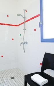 een douche in een badkamer met een zwarte tafel bij Hôtel Le Chevalier Gambette in Saint-Armel