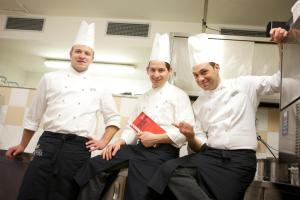 a group of three chefs standing in a kitchen at Hotel Castel Pietra in Fiera di Primiero