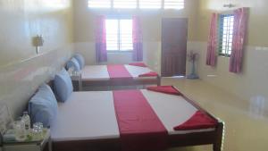 1 Schlafzimmer mit 2 Betten in einem Zimmer mit Fenstern in der Unterkunft Phalla Riverside in Kampong Cham