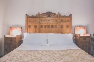 uma cama com uma cabeceira de madeira e duas mesas de cabeceira em Palazzo Speciale B&B em Catânia
