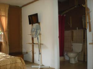 a bedroom with a room with a fan and a toilet at Lodge El Barco in Esterillos