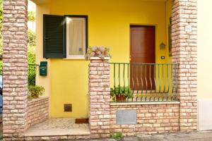 een geel huis met een balkon en een deur bij B&B Percorso Verde in Ponte Valleceppi