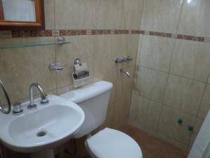 y baño con aseo blanco y lavamanos. en El Cardon Hospedaje en Huacalera