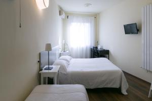 a hospital room with three beds and a window at Albergo Il Cochino in Montale