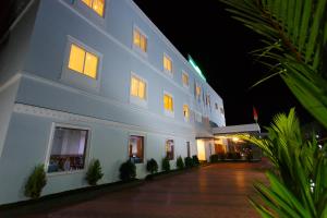 a large white building with lights on at night at Hotel Gopalapuram International in Pollāchi